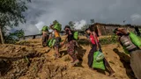 Rohingya vluchtelingen dragen hulpgoederen van Oxfam met zich mee