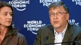 Bill Gates spreekt op het World Economic Forum. Naast hem kijkt een vrouw toe.