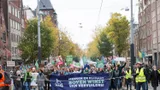 Mensen lopen over straat met borden en spandoeken