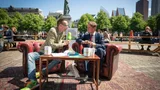 Dolf Jansen zit buiten op het Plein in Den Haag op een bank naast Kamerlid Nijboer (PvdA) en interviewt hem.