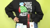 Een persoon met een zwarte trui met tekst "don't stop talking about palestine", olijfolie, zeep en een pin met illustratie van Xaviera Altena.