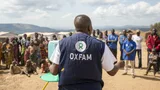 Pascaline Namegabe , Oxfam Public Health Officer, demonstreert een handenwasstation aan een gemeenschap van ontheemde mensen in de Democratische Republiek Congo.