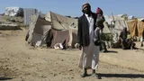 Man met kind op de arm in tentenkamp in Jemen.