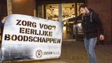 Twee mannen houden een stencil vast met de tekst: Zorg voor eerlijke boodschappen - Oxfam Novib
