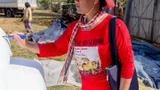 A woman labels a rice bag with a marker pen.