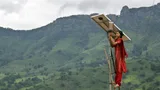 A girl from India standing on a ladder next to a solar panel.