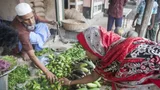 photograph of a woman buying vegetables in a market