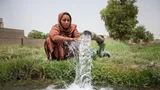 Photograph of a woman next to an irrigation pump