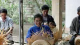 Asian men weaving baskets.