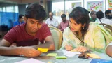 Two young people from Bangladesh looking at post-its.