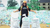 Olufunto Boroffice, the founder and CEO of Chanja Datti, posing next to bags of waste.