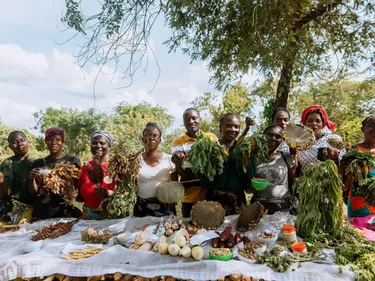 Boeren in Zambia staan achter een tafel met groente.