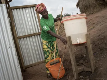 Therese, een gezondheidswerker van Oxfam, maakt latrines schoon.