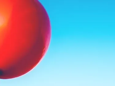 Foto van een rode ballon in de lucht.