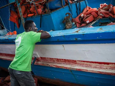 Mahamudi staat bij een boot.