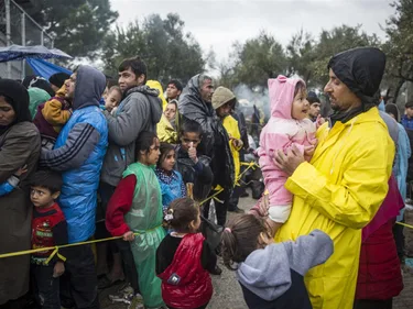Een groep vluchtelingen in poncho's.