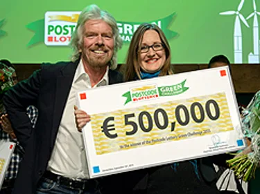 De winnaar van vorig jaar, Ginger Dosier, ontvangt een cheque voor 500.000 euro uit handen van Richard Branson.