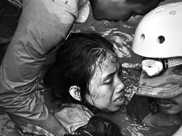 Foto van hulpverleners die meisje uit het water redden op Sulawesi