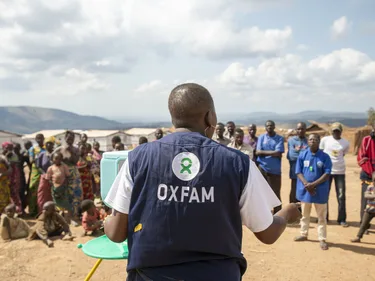 Pascaline Namegabe , Oxfam Public Health Officer, demonstreert een handenwasstation aan een gemeenschap van ontheemde mensen in de Democratische Republiek Congo.
