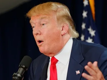 Donald Trump spreekt voor een microfoon.