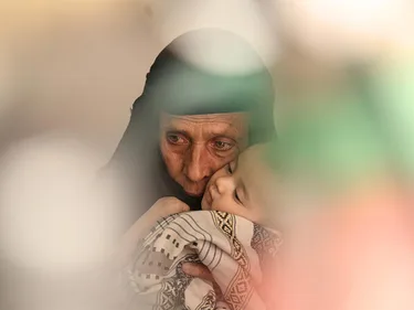 Een vrouw uit Jemen houdt een baby vast
