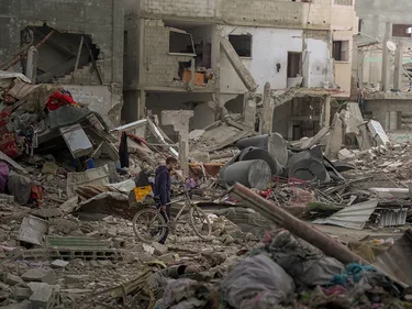 Een man uit Gaza op weg naar wat over is van zijn huis temidden van verwoeste gebouwen
