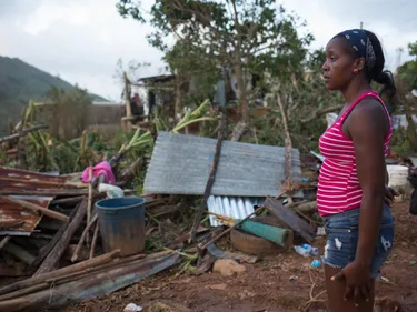 Betty Oguite kijkt naar haar huis, die door orkaan Irma volledig is vernietigd. Met de regen is haar winkel en de kleding die ze daar verkoopt ook verloren gegaan.
