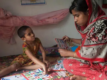 Een jonge vrouw geeft les aan een kind.