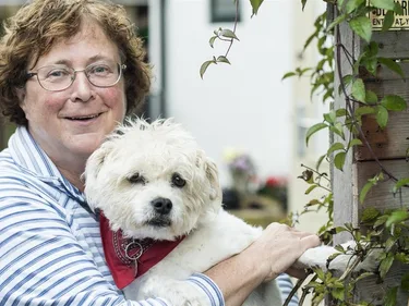 Donateur Heleen Mulders met haar hondje in armen.