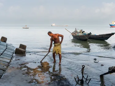 Een visser staat tot aan zijn enkels in het water