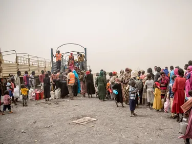 Mensen bij de Zuid-Sudanese grens op weg naar ons ons vluchtelingenkamp in Renk. Ze staan in de rij voor de vrachtwagen.