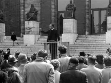 Pater Simon Jelsma spreek een groep mensen toe.