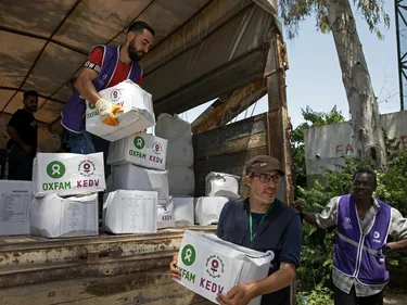 Hulpverleners laden noodhulppakketten uit een vrachtwagen.