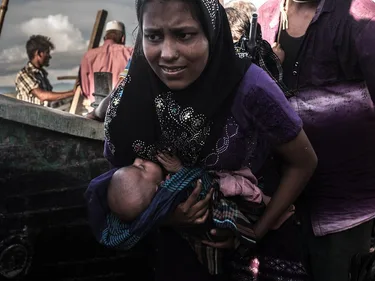 Vrouw met baby voor een boot