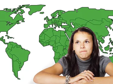 Foto van een meisje dat voor een wereldkaart zit