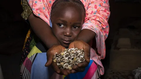 Hauwau met haar handen voor haar dochter Safiya.