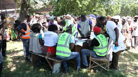 Vrijwilligers overleggen over het uitdelen van hygiënekits en shelterzeilen in het Bangula noodkamp in Nsanje, Malawi.