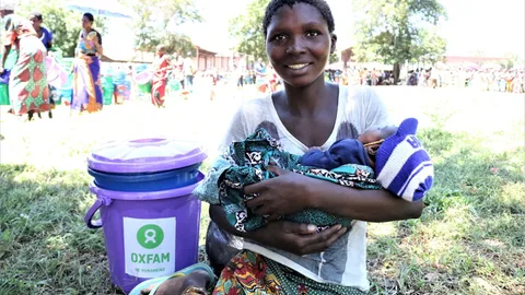 Zainabu houdt haar baby vast in het Bangula noodkamp in Malawi.