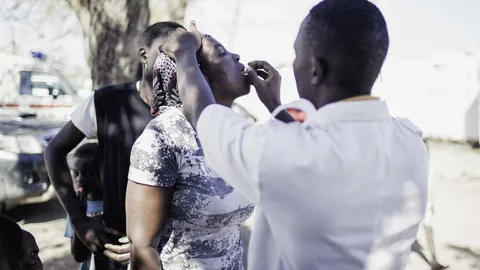 Een arts geeft een vrouw medicatie.