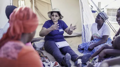 Emilia Moussa van Oxfam geeft een groep vrouwen voorlichting over vaccinaties en hygiëne.