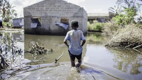 De kleine Jose waadt door water wat tot zijn knieën komt.