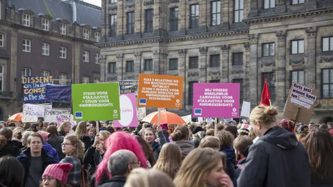 Impressie van vrouwen tijdens de Womens March met een aantal borden boven hen in de lucht.