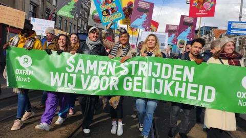 Vrouwen tijdens de Feminist March houden een spandoek vast met de tekst: Samen strijden wij voor gelijkheid