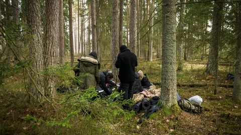 Een groep vluchtelingen in een bos.