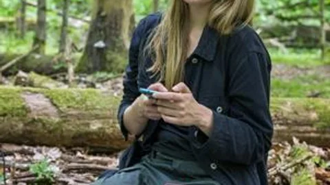 Dominika Ożyńska zit in een bos.