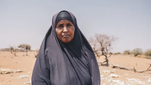 Mareya uit Kenia staat op een zandvlakte.