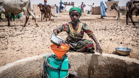 Een jongen bij een waterput in de woestijn.