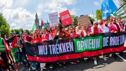 Demonstranten in het rood met spandoek 'Wij trekken opnieuw die rode lijn'