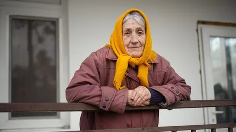 Tamara leunt op een balustrade. Ze draagt een hoofddoek.