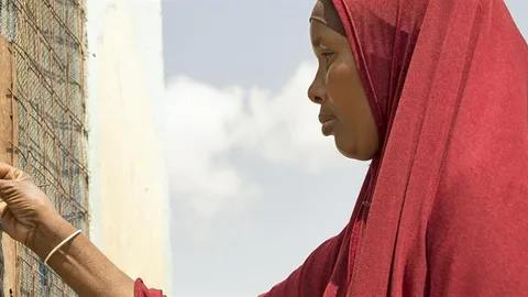 Een vrouw houdt een kaart voor de waterautomaat